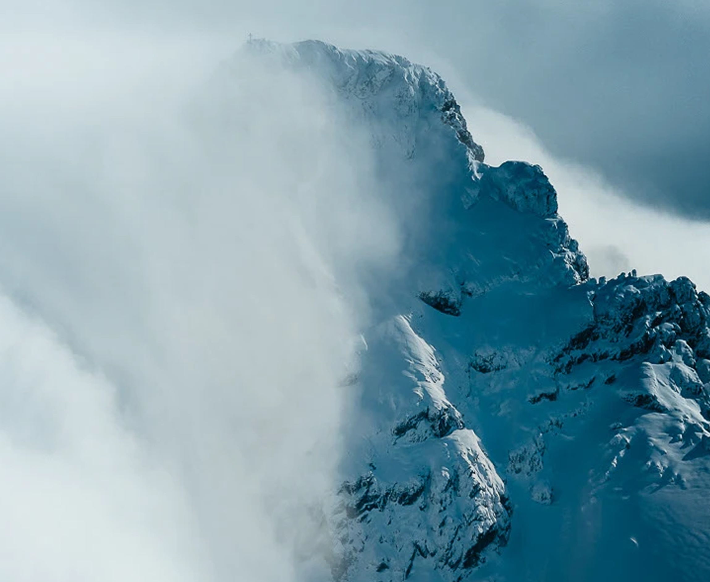 Snow-covered mountain peak in mist